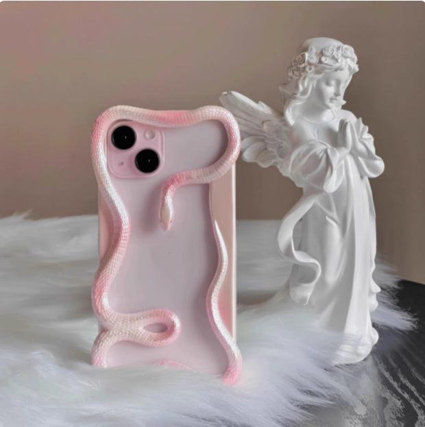 Stylish 'SausageSnuggle' iPhone Case with a unique snake design on a soft surface, next to a white angel figurine. Perfect for expressing personality while keeping your phone protected. Explore our vibrant collection of trendy iPhone cases!